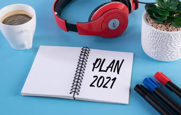 Headphones, flower and notebook with Plan 2021 text