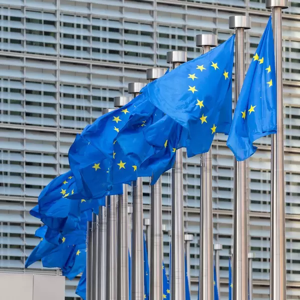 Headquarter of the European Commission in Brussels with flags of the European Union in the foreground