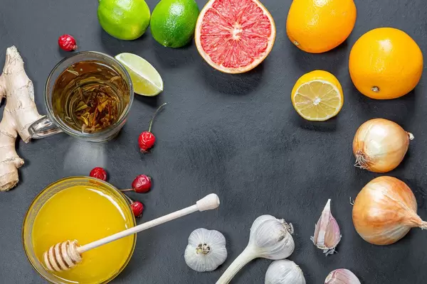 Health food to boost immune system. Frame with citrus, green tea, ginger root, onion and garlic on black background. Top view (Flip 2019)