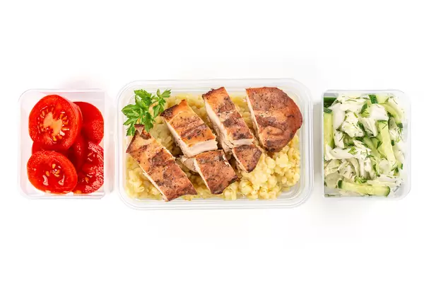 Healthy balanced lunch box on white background, top view, home food for office concept
