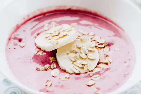 Healthy breakfast. Close up of strawberry smoothie with bananas and oat flakes.