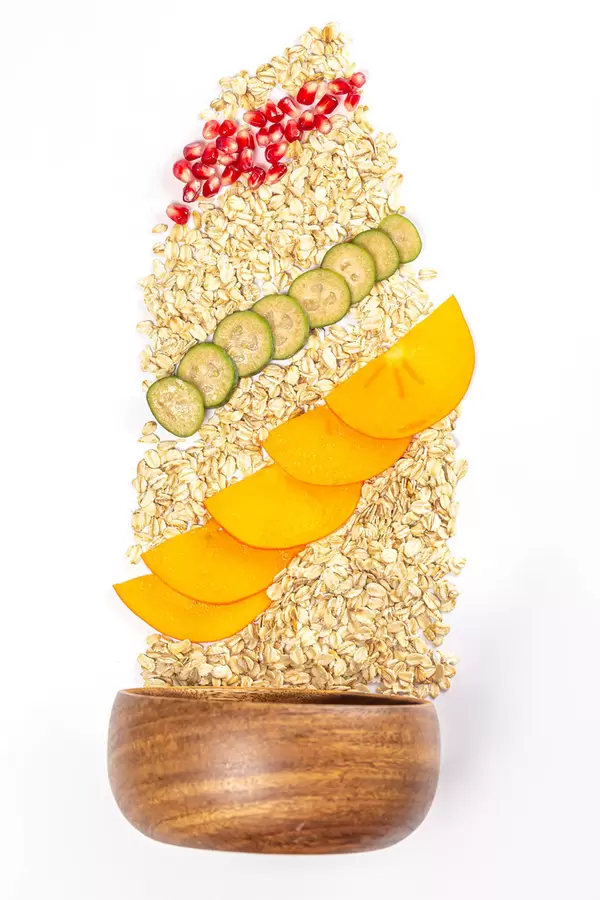Healthy breakfast ingredients, wooden bowl with oatmeal and fruit, top view