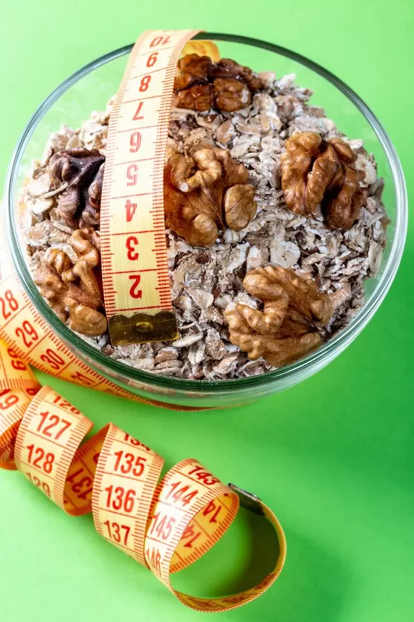 Healthy breakfast oatmeal with nuts and measuring tape
