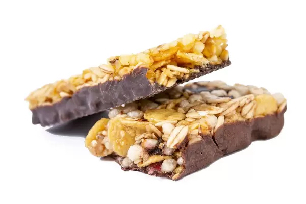 Healthy Cereal Bar with Cranberries and Milk cream above white background (Flip 2019)