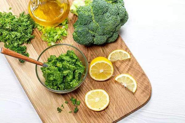 Healthy eating background. Puree with fresh herbs and vegetables on the kitchen Board with lemon slices and olive oil (Flip 2019)
