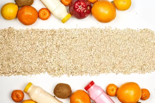 Healthy food background with bottles of detox smoothies and pile of organic fruits