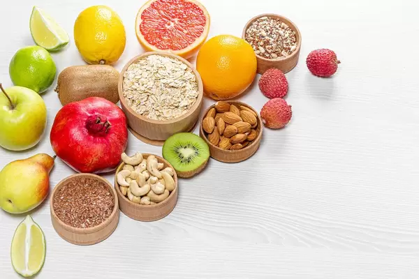 Healthy food ingredients. Fruits, nuts, seeds on wooden white background (Flip 2019)