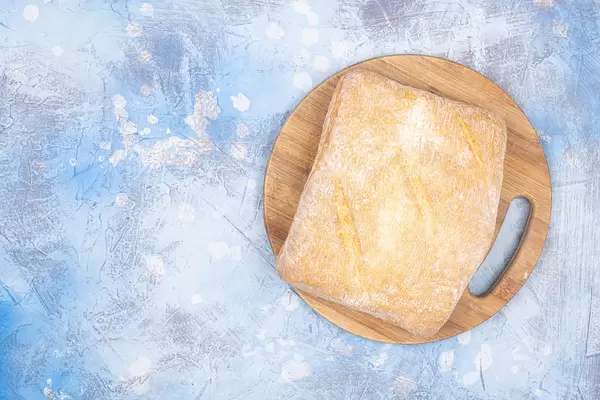 Healthy Homemade Bread on the wooden board with blue background