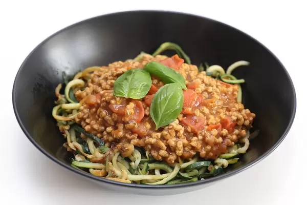 Healthy lunch for a vegan diet, with sunflower bolognese as meat substitute and green courgette spaghetti.