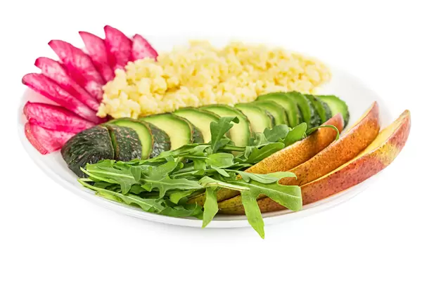 Healthy lunch with couscous porridge, vegetables, arugula and mango pieces