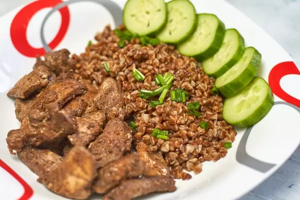 Healthy salad for lunch. A plate of buckwheat porridge, chicken fillet and cucumber slices