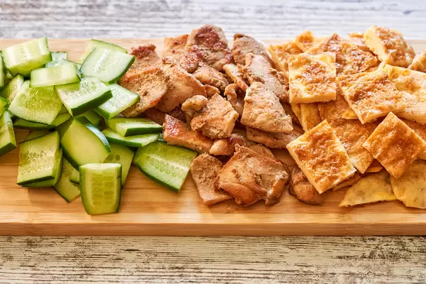 Healthy salad ingredients - cucumber, fried chicken fillet and egg omelet slices