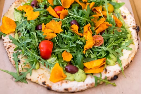 Healthy vegan Pizza with Guacamole and Salad topping