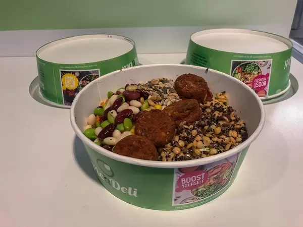 Healthy, vegetarian Picadeli salad, with meatless vegetable balls made of tomatoes & basil, power grain mix and beans in a green to-go box