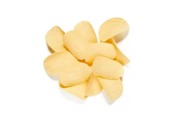 Heap of fresh potato chips isolated on white