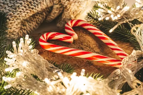 Heart made of lollipops on a wooden background with a garland