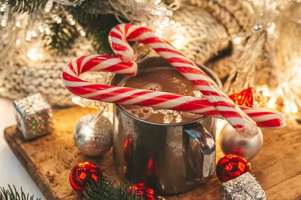 Heart of lollipops on a mug with coffee and christmas decor