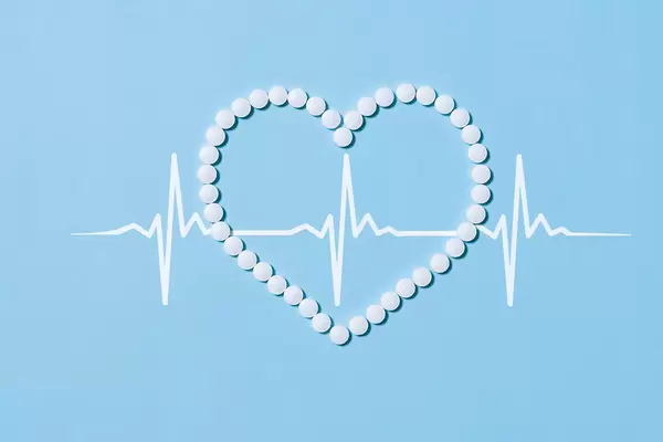 Heart shape made of medical pills and cardiogram