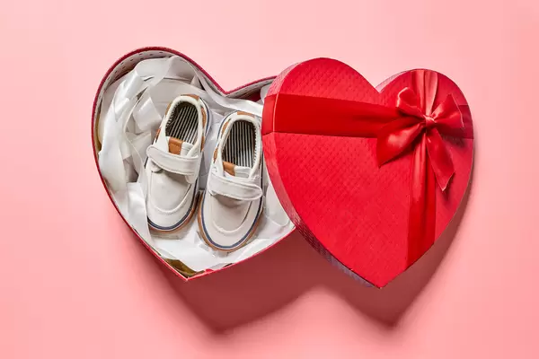 Heartshape gift box with new baby's shoes
