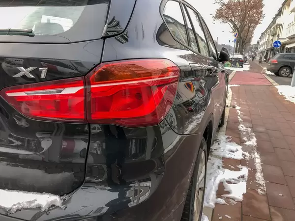 Heck eines in der Stadt am Straßenrand geparkten schwarzen Autos im Winter