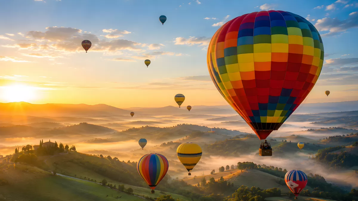 Heißluftballons über nebligen Hügeln im Morgenrot