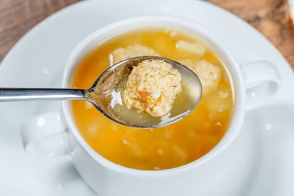 Heiße Suppe mit Fleischbällchen auf einem Löffel