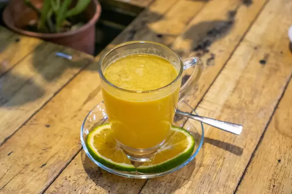 Heißer Orangen-Zimt Tee mit Orangenscheiben auf einem Holztisch