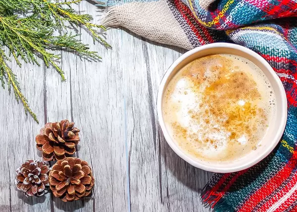 Heißgetränk im Winter: Kaffee Latte neben Weihnachtsdeko