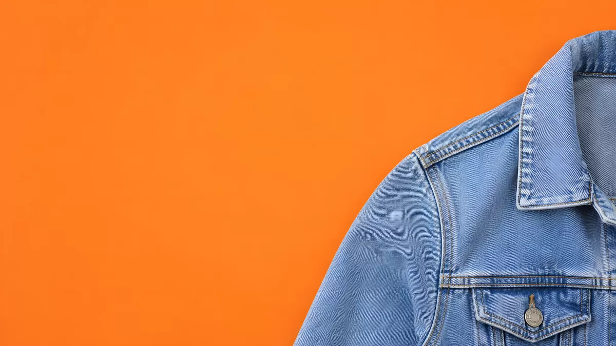 Hellblaue Jeansjacke vor leuchtendem Orangehintergrund