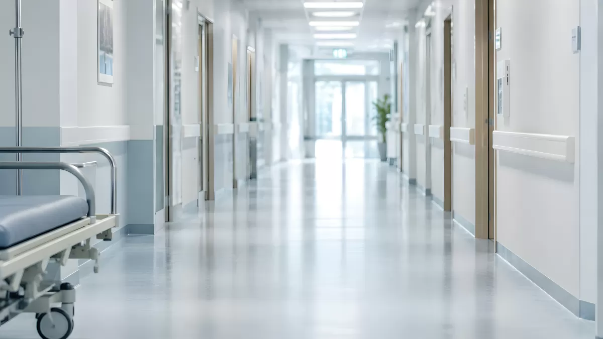 Heller Krankenhausflur mit Krankenbett und Türen