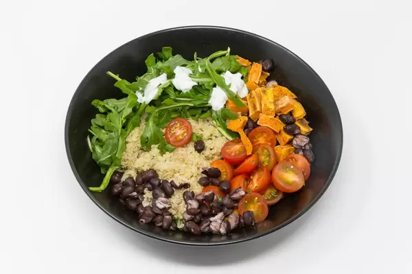 Hello Fresh - Quinoa with aragula with sour cream dip , black beans, cherry tomatos and sweet cinnamon potatoes in black bowl