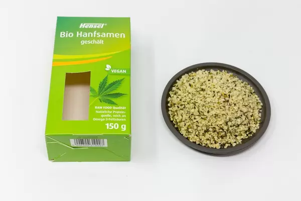 Hensel - Geschälte Bio-Hanfsamen auf einem Teller mit Verpackung
