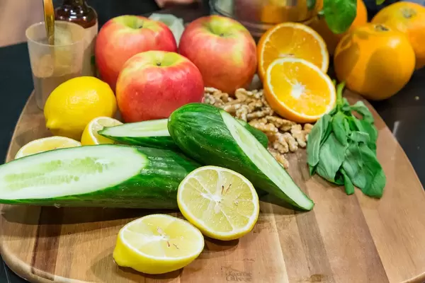 Herbstliche Kochzutaten: Frische Gurken, Äpfel, Nüsse und Zitrusfrüchte auf einem Holzbrett