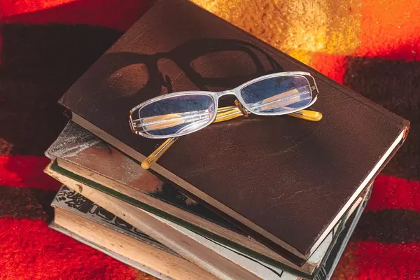 Herbststimmung mit Büchern und Brillen auf einer bunten Decke
