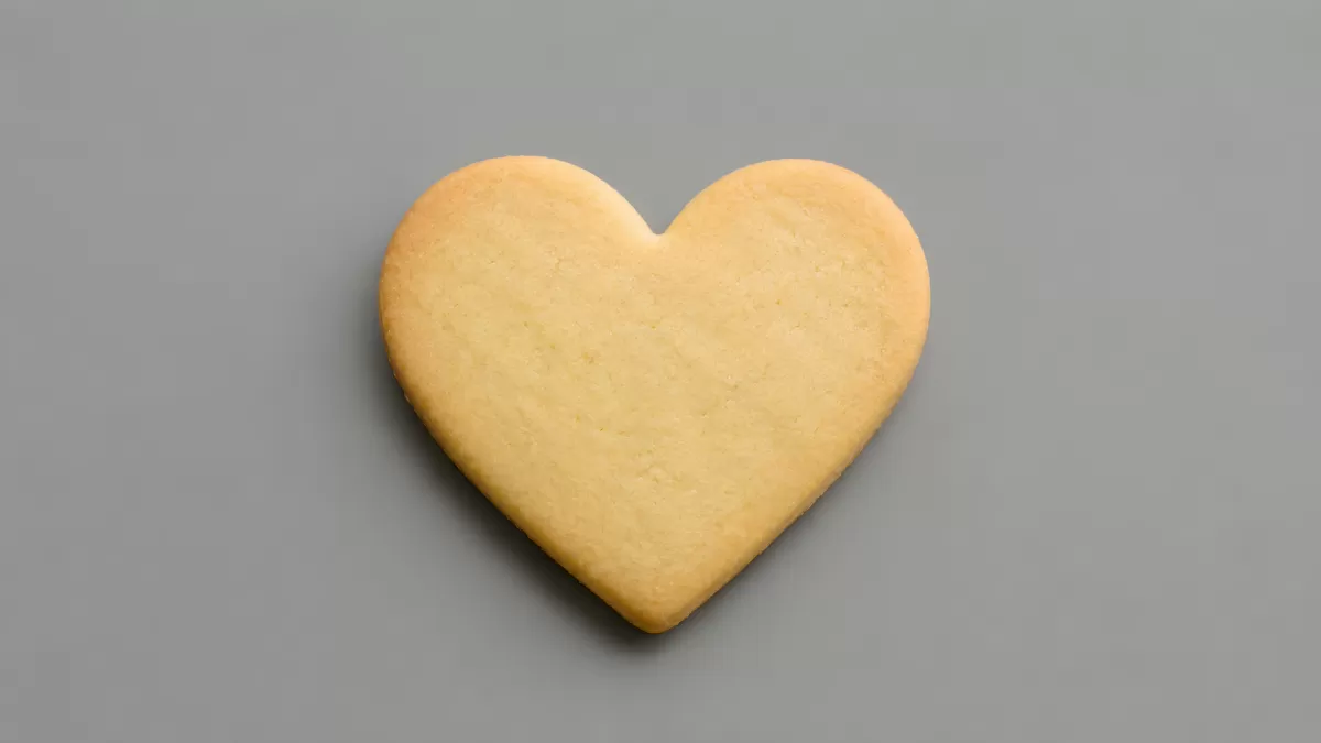 Herzförmiger Butterkeks auf grauem Hintergrund