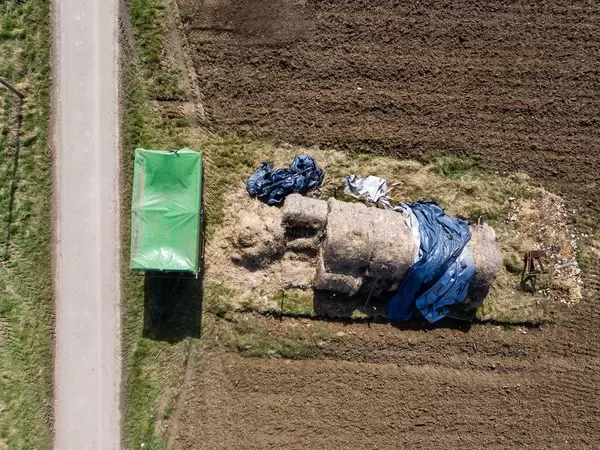 Heuhaufen und ein Anhänger aus der Vogelperspektive