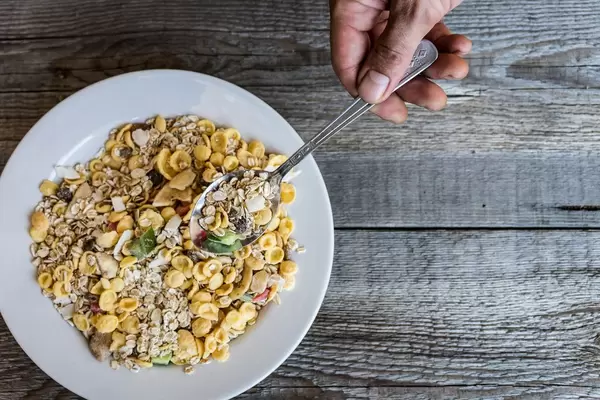 High Angle View of Hand Holding The Spoon With Muesli