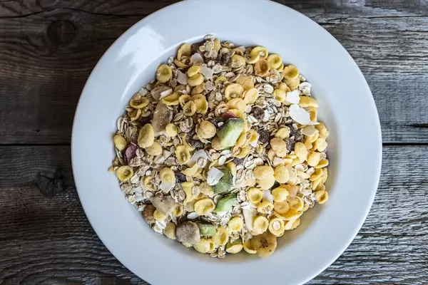 High Angle View of the Muesli in the White Plate on the Wooden Table