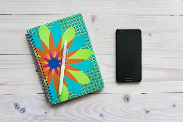 High Angle View of the Notebook, Pen and Smartphone