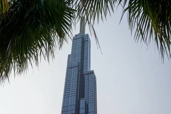 Highest Building of Vietnam Vincom Landmark 81 Skyscraper behind a Palm Tree from below in Ho Chi Minh City, Vietnam