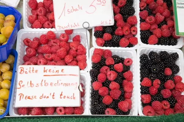 Himbeeren und Brombeeren in Plastikbechern