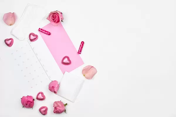 Hintergrund mit Platz für Text, Menstruation-Kalender, Schokoherzen, Rosen, Slipeinlagen und Tampons