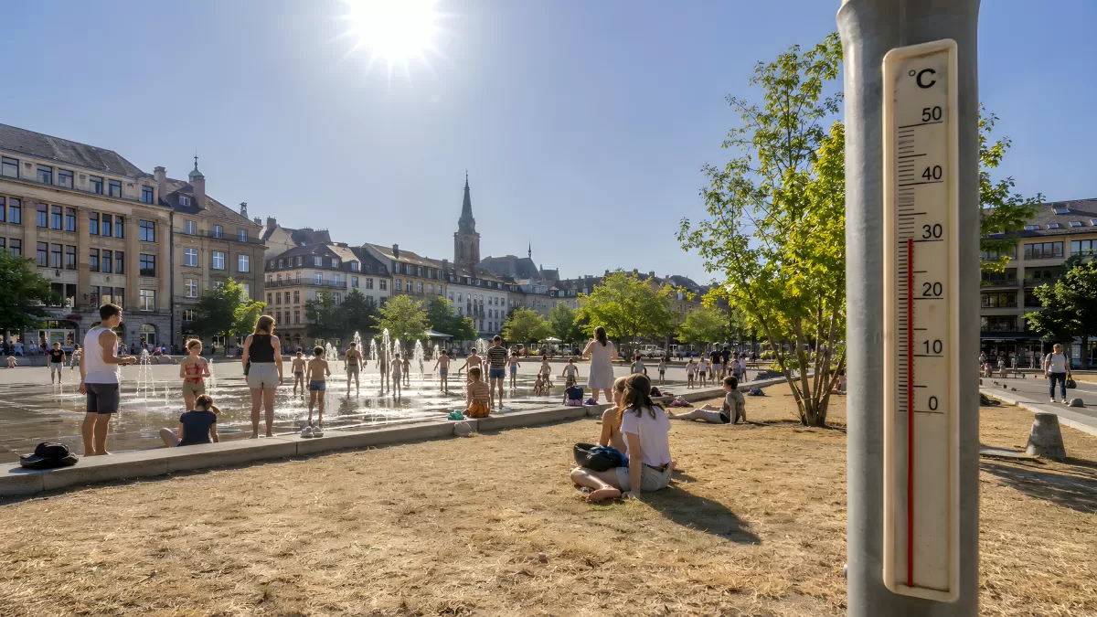 Hitzetag auf dem Stadtplatz mit Thermometer im Vordergrund