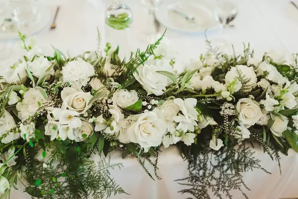 Hochzeitsblumen Komposition aus weißen Rosen auf einem Tisch