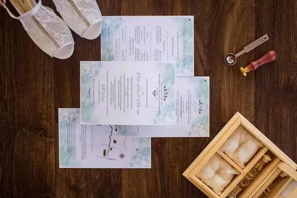 Hochzeitsdetails wie Brautschuhe, Schatulle für Trauringe, Hochzeitseinladung und Stempel für Wachssiegel
