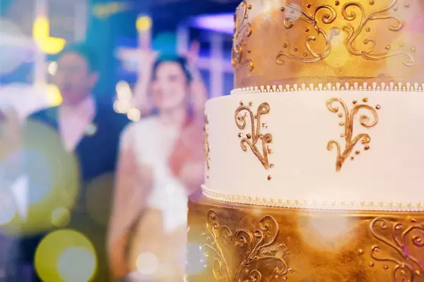 Hochzeitstorte mit Braut und Bräutigam im Hintergrund