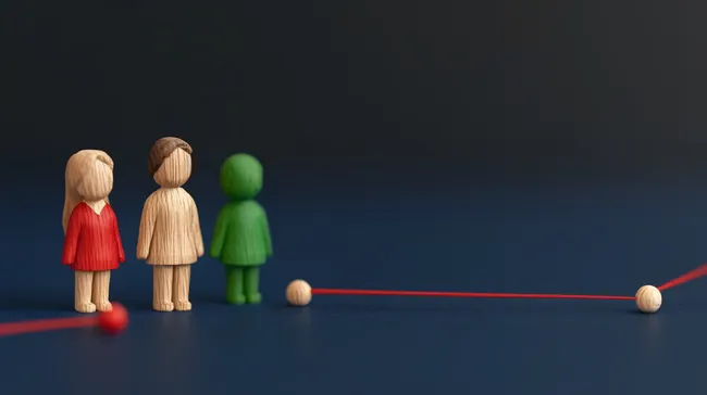 Hölzerne Figuren verknüpft durch roten Faden