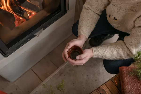 Holding Hot Tea Near FirePlace