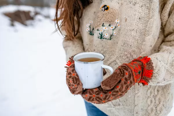 Holding Hot Tea Outdoors With Warm Mittens