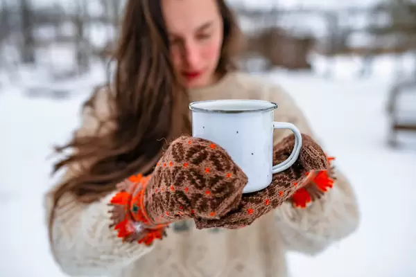 Holding Tea In Metal Cup With Wool Mittens
